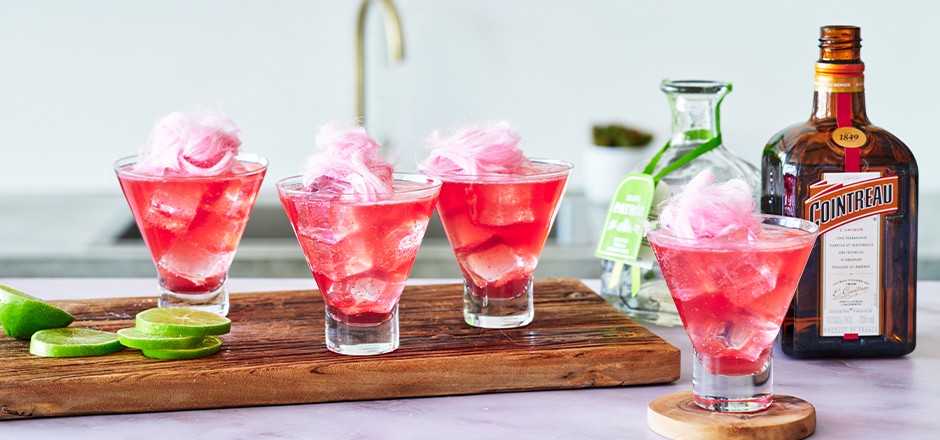 pink fairy floss margaritas on a wooden chopping board