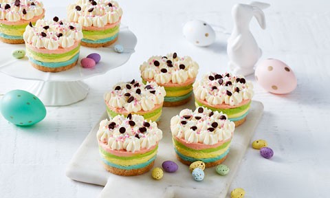 Eight mini rainbow cheesecakes sprinkled with choc chips