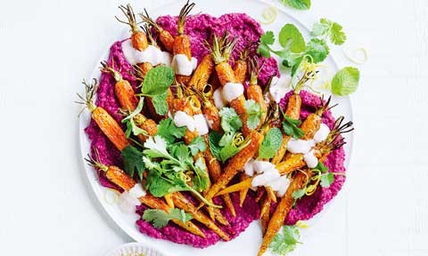 Moroccan-style salad with spiced carrots on a dish with a coriander and mint leaf garnish.