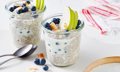 Two blueberry chia pots top with sliced apple and flaked coconut