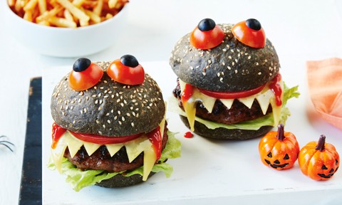 Two monster burgers decorated with tomato and blueberry