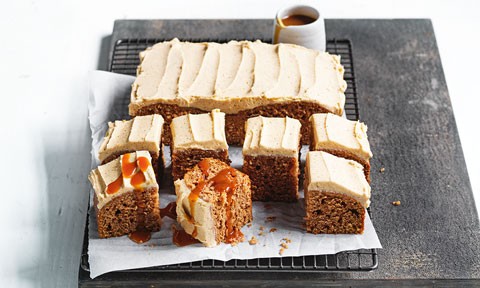 Whole spiced apple cake with brown butter icing with half cut into squares