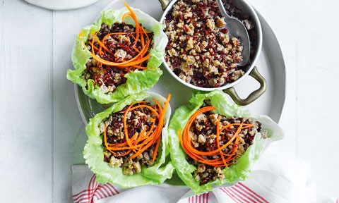 3 lettuce cups filled with turkey san choy bow with shaved carrot on top