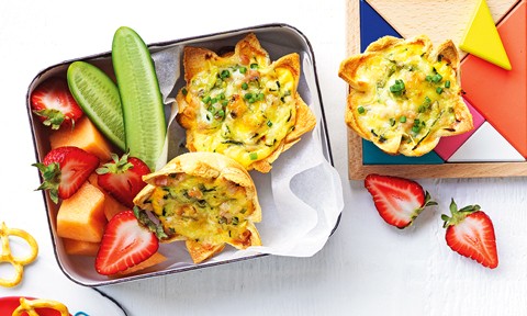 Mini bread quiches served in a lunch box with fresh fruit and vegetables