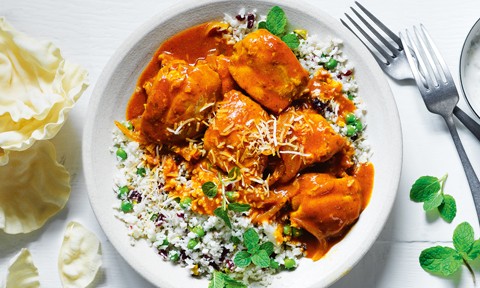 Butter chicken served on top of cauliflower rice with mint as a garnish