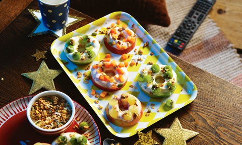 Doughnut-shaped apple slices topped with yoghurt, fruit and granola.