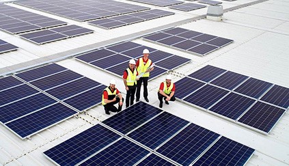 Coles team members inspecting solar panels on the roof of a Coles supermarket in Drysdale, Victoria