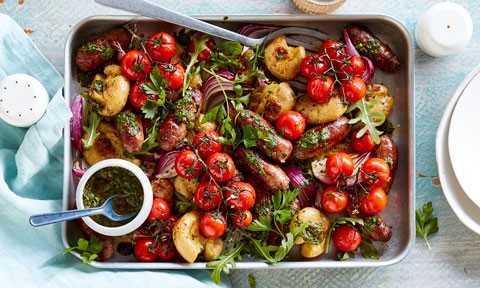 Sausage and potatoes with roasted tomatoes and basil served in a baking dish