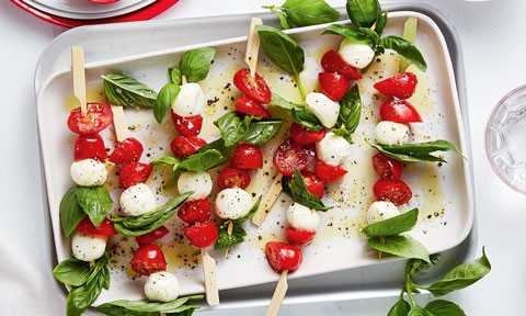 A tray of skewered perino tomatos, basil and cheese