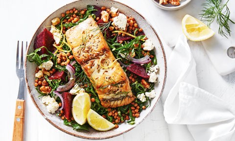 Barramundi served on top of silverbeet, lentil and fetta salad with a lemon wedge as a garnish 