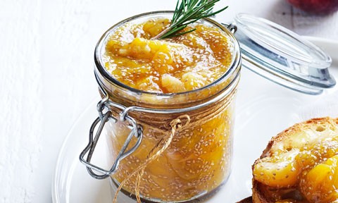 A glass jar of peach and maple chia jam topped with rosemary