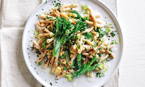 A plate of vegan mac and cheese topped with spring onions