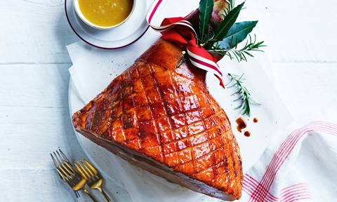 A maple glazed half leg ham decorated with ribbon and rosemary