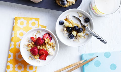 Two bowls of oats with milk and fresh berries on top
