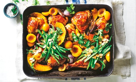 Chicken, apricot and garlic in a baking tray topped with green beans and flaked almonds
