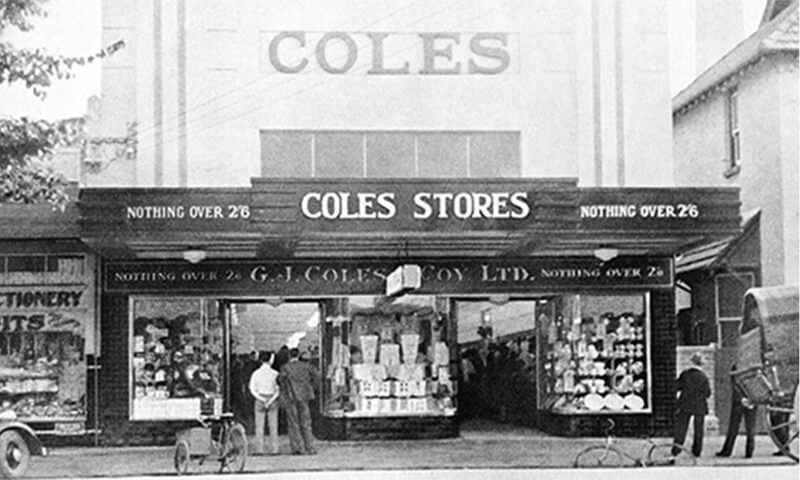 black and white image of old coles store front with customers looking into windows