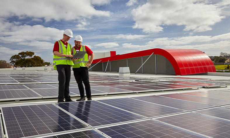 Coles team members inspect solar panels on roof of Coles' supermarket at Drysdale, Victoria