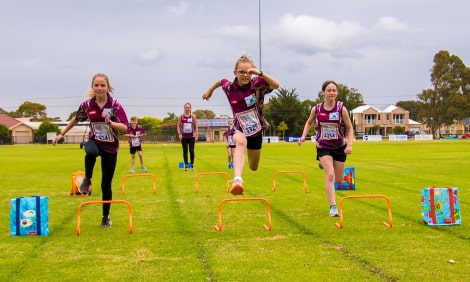 Children crossing mini hurdles on the playground