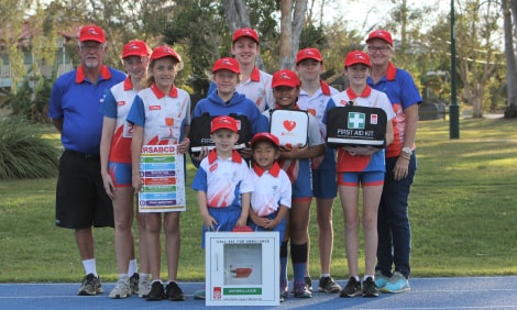 Children holding first aid kit and defibrillator