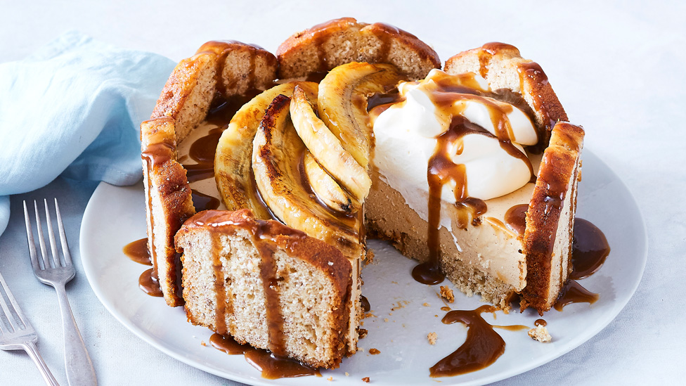 A banana bread cheesecake topped with caramelised bananas and cream