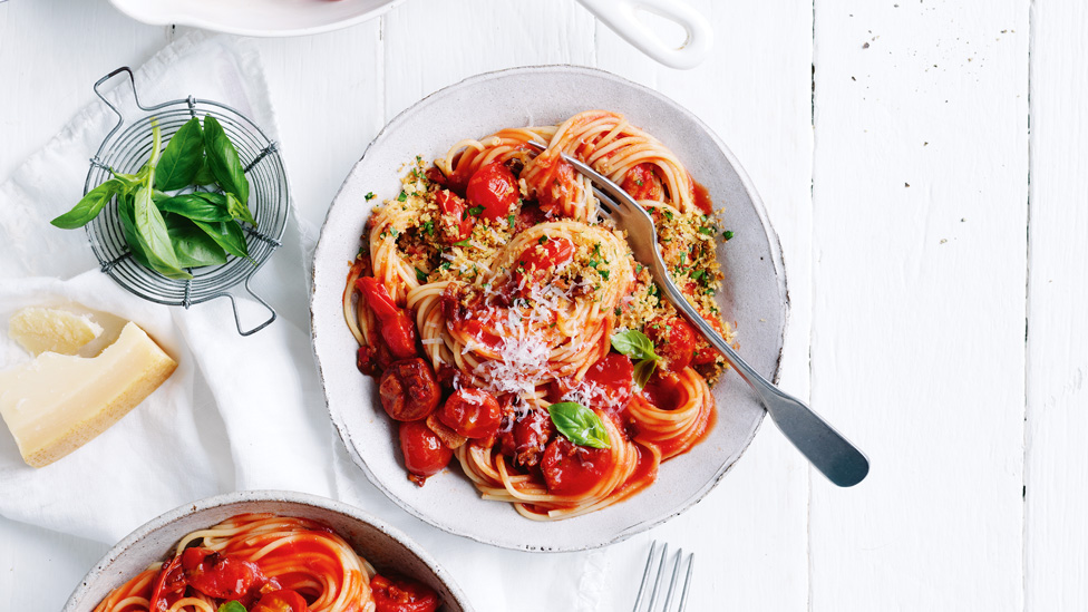 A bowl of spaghetti with pancetta, cherry tmatoes and bread crumbs