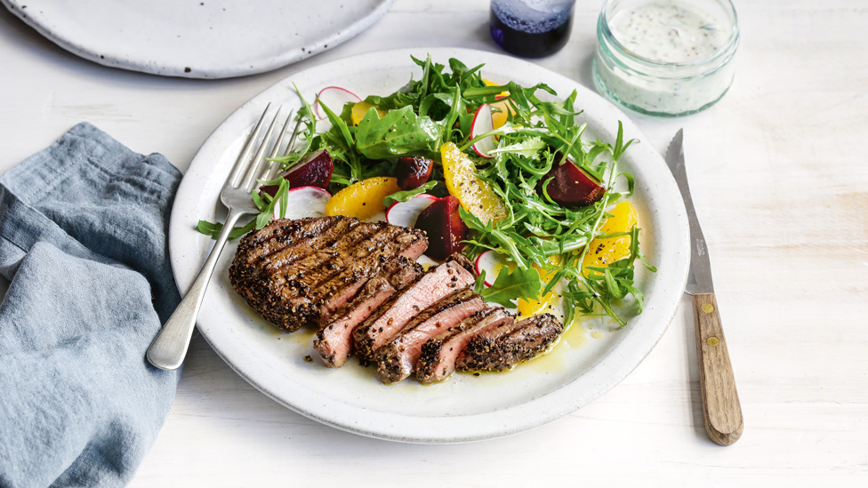 Thickly sliced pepper-crusted beef with beetroot salad, yogurt mixture and bread