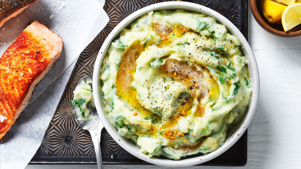 1 salmon portion served beside a bowl of burnt butter colcannon