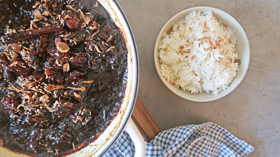 A rich pot of saucy braised pork with a serving of fluffy jasmine rice.