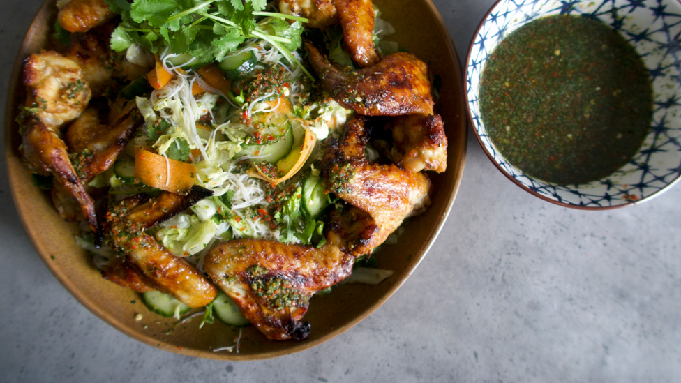 A plate of golden chicken wings with vermicelli noodles and mixed vegetables.