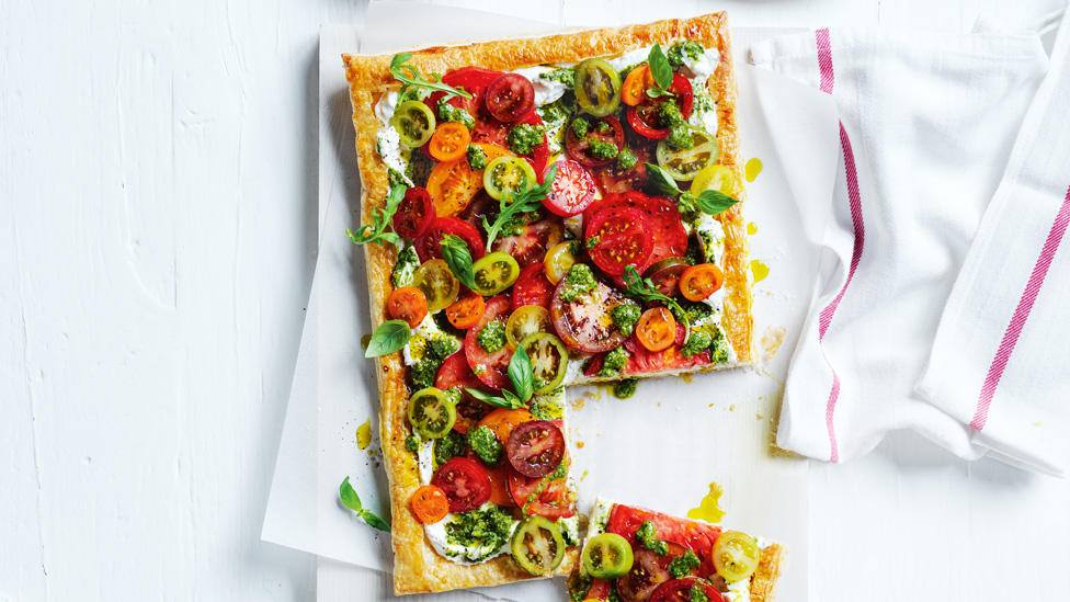 A tomato ricotta tart with sprigs of fresh herbs