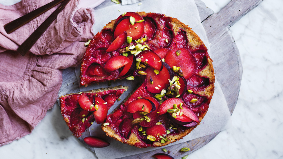 Upside-down Plum, Pistachio and Cardamom Cake on grey board