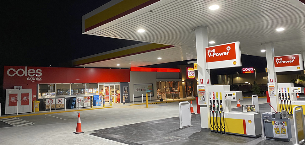 Shell Coles Express Forecourt with fuels pump and canopy and the Coles Express store in the background and the fuel price board on the right of the image