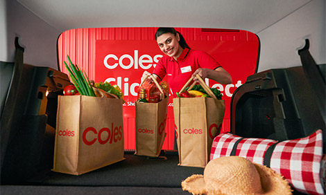 Person loading groceries into a car boot