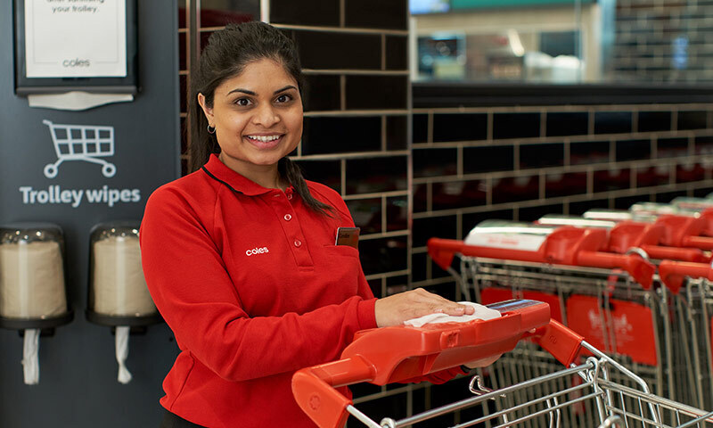 Person wiping shopping trolley handles