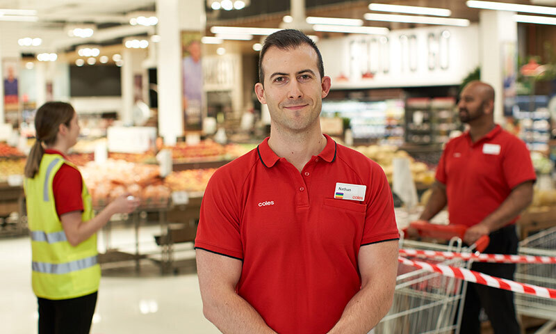 Coles employee standing in a Coles store