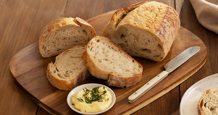 Laurent bread on a wooden board with butter