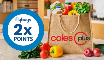A Coles Plus hessian bag filled with fresh fruits, milk and eggs on a marble kitchen bench, roundel on the right reads: Flybuys 2 times Points