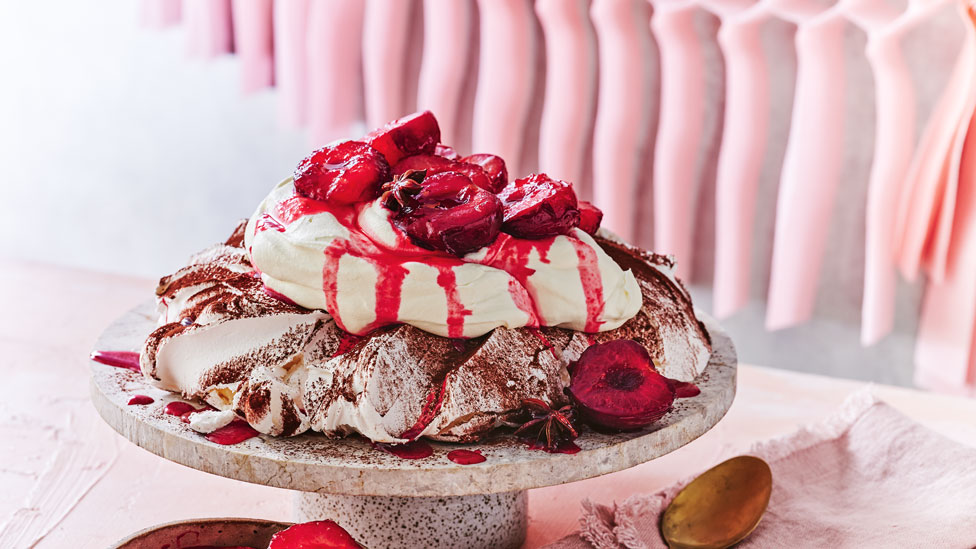 Chocolate-dusted pavlova with spiced plums