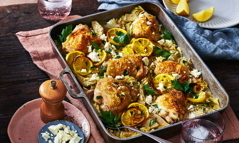 A tray of golden chicken thigh cutlets on a bed of risoni with lemon, herbs and fetta.