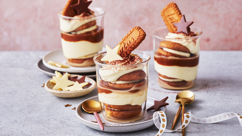 caramel cheesecake cups in glass cups with biscuits and stars to decorate