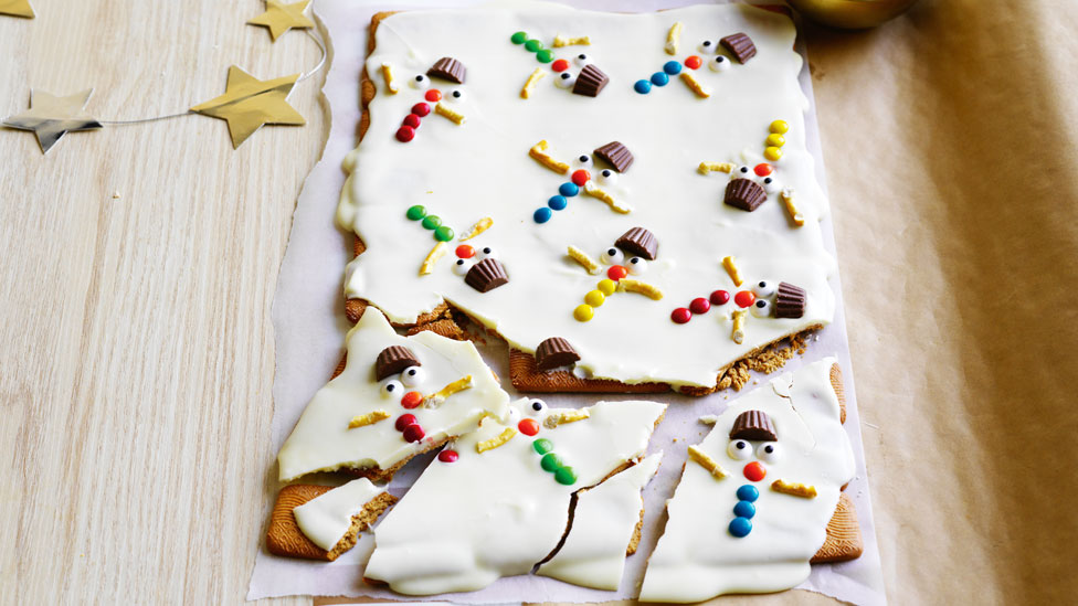 chocolate bark with melted snowman decorated with chocolate decorations