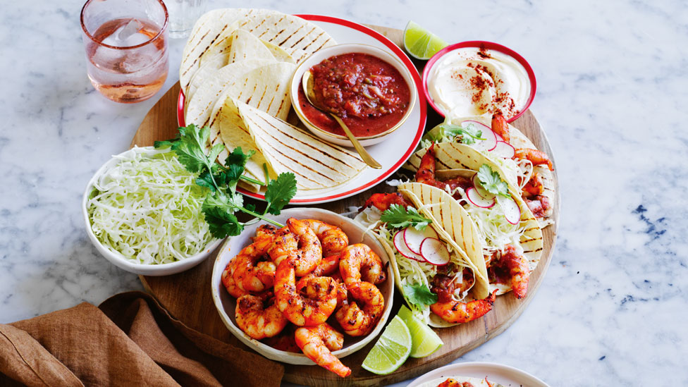 Prawn tacos with BBQ tomato salsa on a large round plate