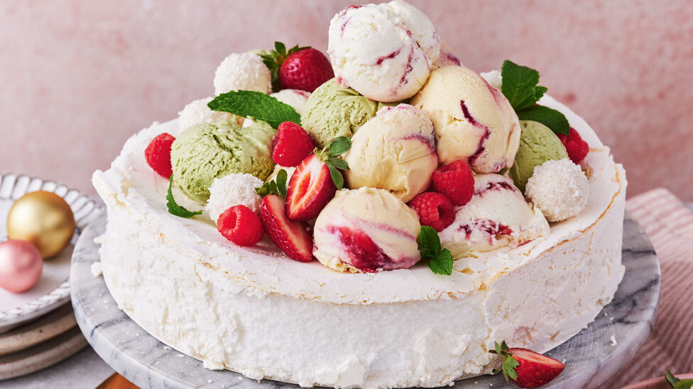 pavlova topped with lots of berries and assorted ice cream flavours