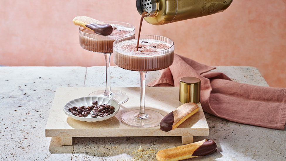 Two tiramisu espresso martinis on a wooden board