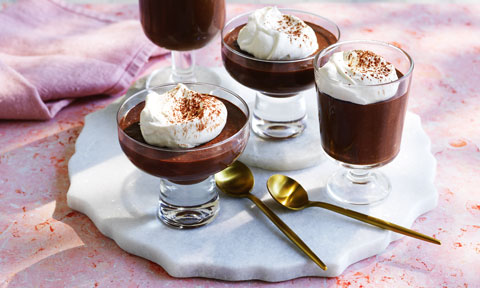 Four mocha mousse cups in various size glasses on a white plate