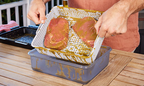 A person marinading steaks
