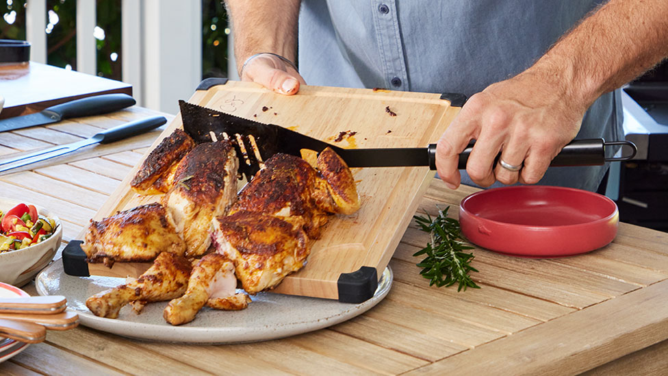 Cooked whole chicken on a chopping board