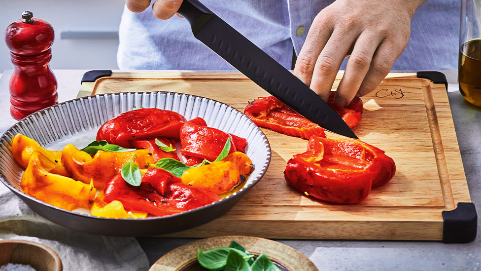 Capsicum being sliced with a knife.