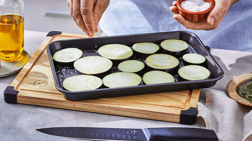 Slices of eggplant on a baking tray.