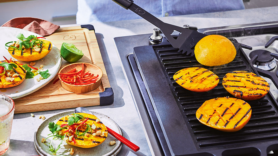 Mango on a grill plate of a BBQ.
